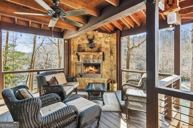 wooden deck with an outdoor living space with a fireplace and ceiling fan