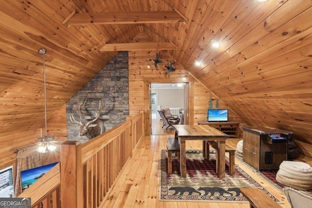 office area featuring wooden walls, wood ceiling, lofted ceiling with beams, and light wood finished floors