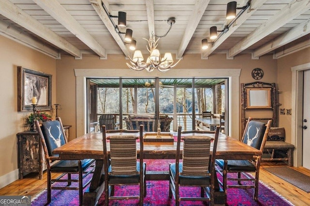 dining room with a chandelier, wood finished floors, beam ceiling, and a healthy amount of sunlight