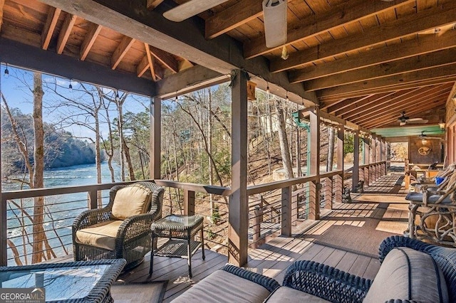 deck with a water view and a ceiling fan