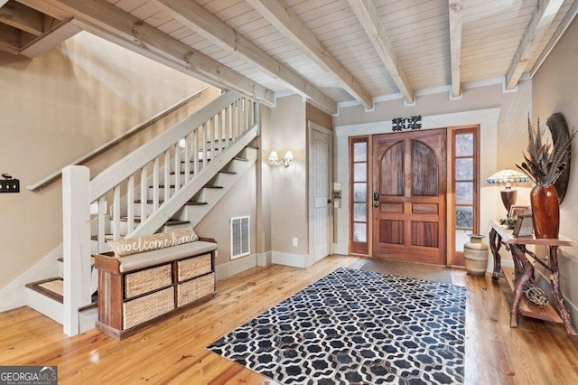 entrance foyer with visible vents, wood ceiling, stairway, wood finished floors, and beamed ceiling