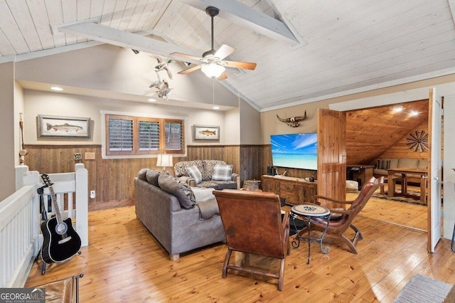 living room with a wainscoted wall, wood ceiling, light wood-style flooring, and vaulted ceiling with beams