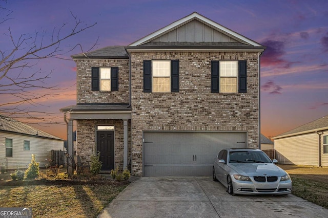 view of front facade featuring board and batten siding, brick siding, driveway, and a garage