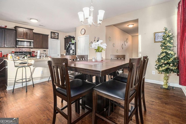 dining space featuring baseboards, dark wood finished floors, and a chandelier