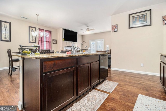 kitchen with dishwasher, dark wood-style flooring, dark brown cabinetry, and baseboards