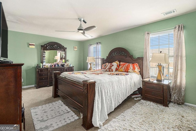 bedroom featuring a ceiling fan, visible vents, carpet floors, and baseboards