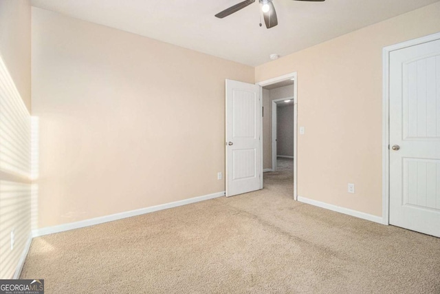 unfurnished bedroom with carpet, a ceiling fan, and baseboards