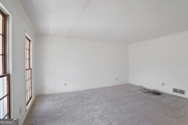 carpeted empty room with visible vents and crown molding