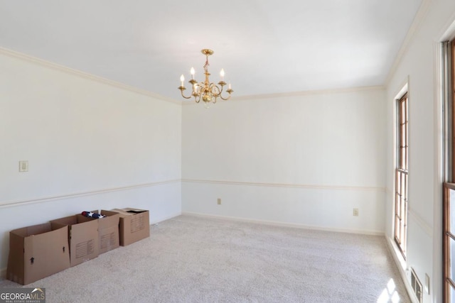 unfurnished room featuring visible vents, carpet flooring, crown molding, and a notable chandelier