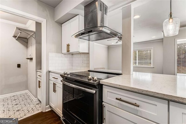 kitchen with electric stove, ornamental molding, light stone countertops, wall chimney range hood, and white cabinetry