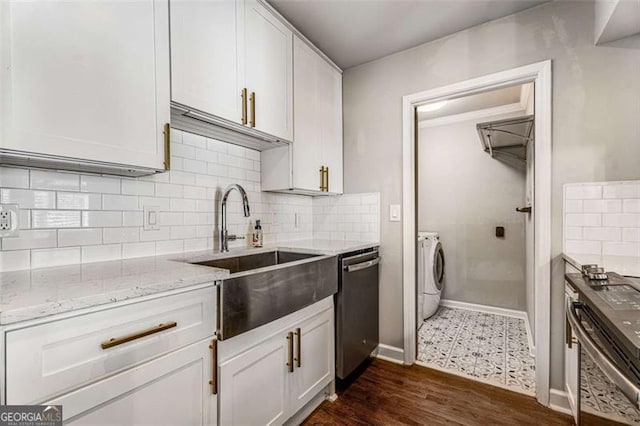 kitchen featuring light stone counters, dark wood-type flooring, a sink, independent washer and dryer, and dishwasher