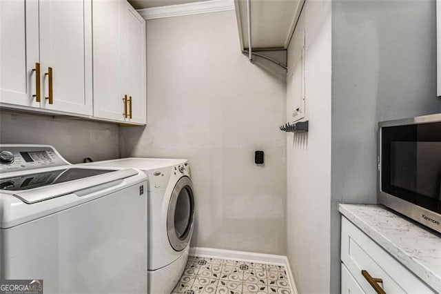 clothes washing area with crown molding, separate washer and dryer, cabinet space, and baseboards