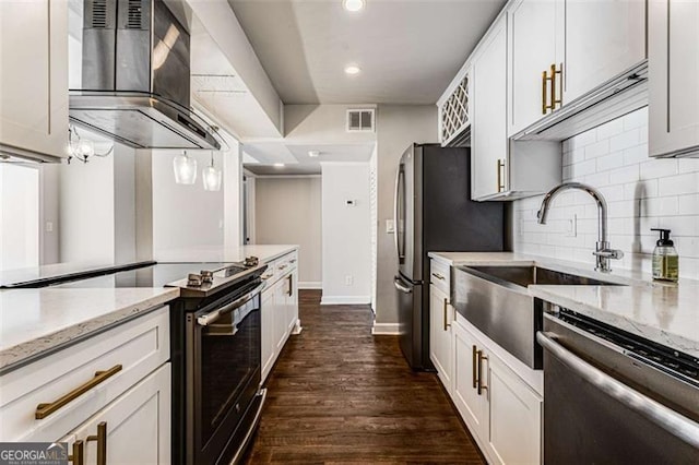 kitchen featuring dark wood-type flooring, visible vents, appliances with stainless steel finishes, decorative backsplash, and wall chimney exhaust hood