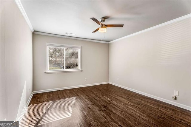 spare room featuring ornamental molding, dark wood-type flooring, ceiling fan, and baseboards