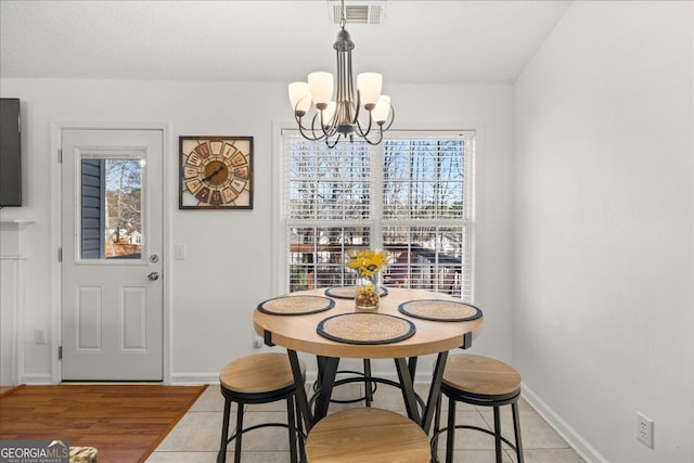 dining area with baseboards, visible vents, a chandelier, and wood finished floors