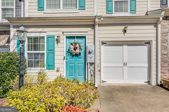 property entrance with a garage and concrete driveway