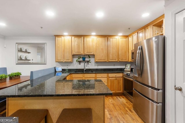 kitchen featuring light wood finished floors, a peninsula, stainless steel appliances, open shelves, and a sink