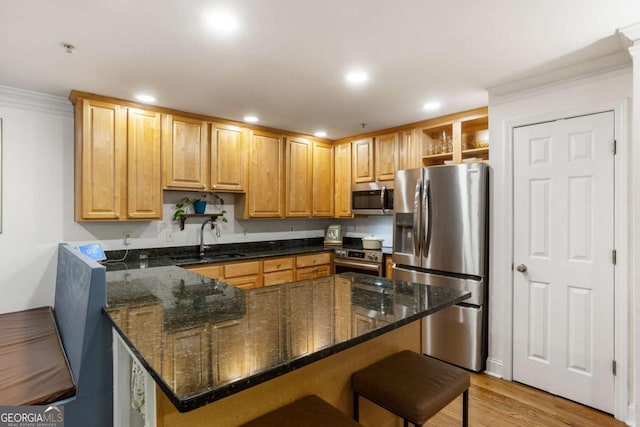 kitchen with a breakfast bar area, a sink, appliances with stainless steel finishes, open shelves, and dark stone countertops