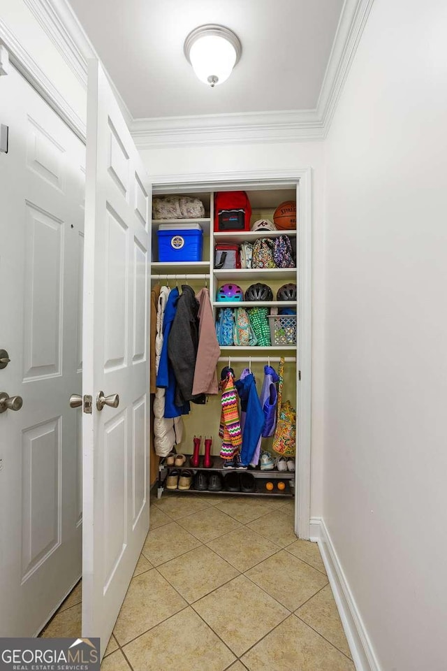 mudroom with ornamental molding, baseboards, and light tile patterned floors