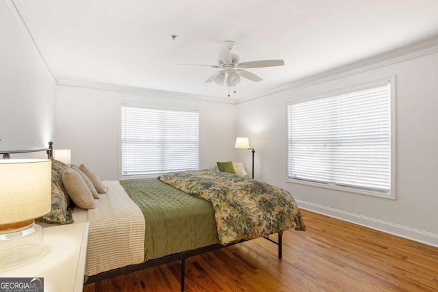 bedroom with ceiling fan, ornamental molding, wood finished floors, and baseboards