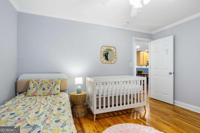 bedroom featuring ornamental molding, ceiling fan, baseboards, and wood finished floors