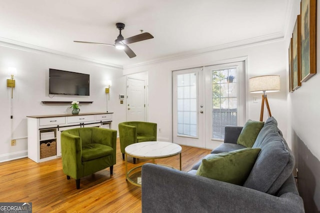 living room featuring a ceiling fan, baseboards, light wood-style floors, ornamental molding, and french doors