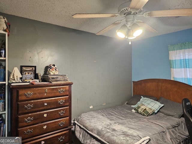 bedroom with a ceiling fan and a textured ceiling