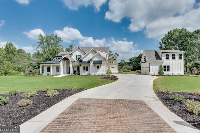 modern inspired farmhouse featuring driveway, a garage, a front lawn, and board and batten siding