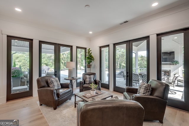 interior space with visible vents, ornamental molding, recessed lighting, french doors, and light wood finished floors