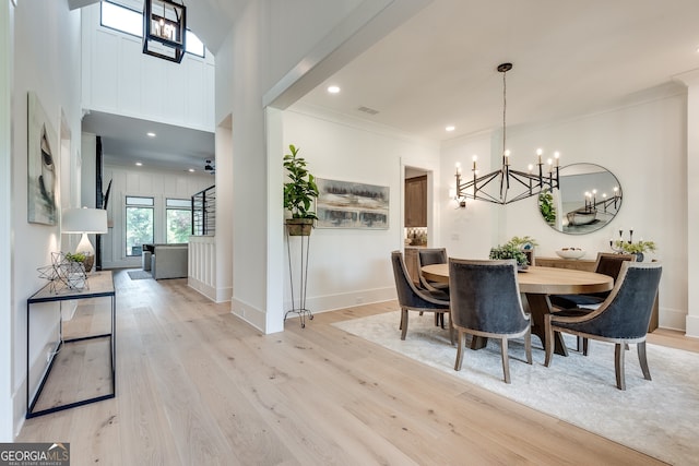 dining area with light wood finished floors, baseboards, ceiling fan with notable chandelier, crown molding, and recessed lighting