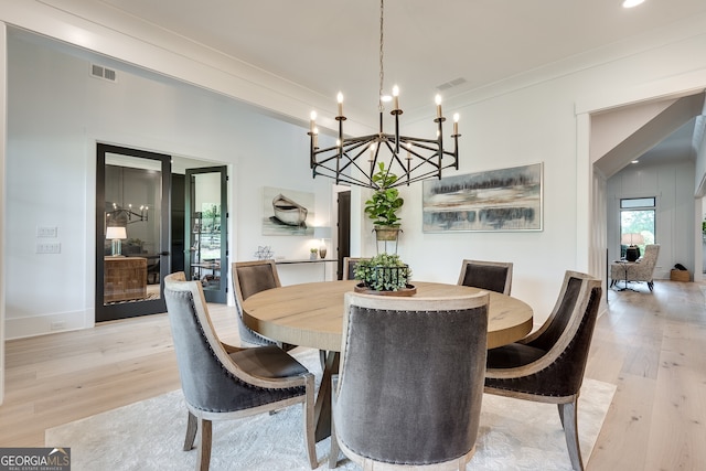 dining area with light wood-style floors, visible vents, and ornamental molding