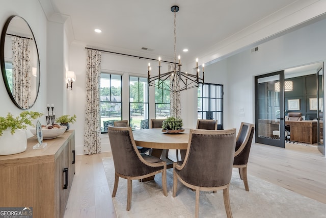 dining space featuring french doors, ornamental molding, light wood-type flooring, and visible vents