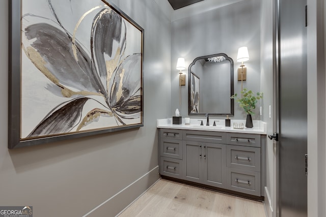 bathroom featuring vanity, baseboards, and wood finished floors