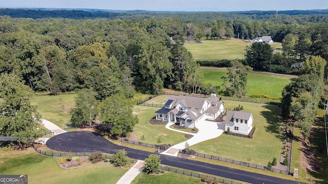 birds eye view of property with a forest view and a rural view