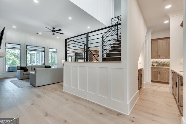 unfurnished living room featuring stairs, recessed lighting, light wood-type flooring, and crown molding