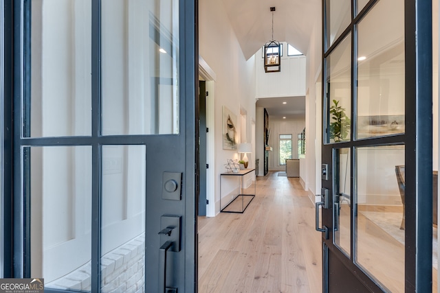 entrance foyer with a towering ceiling and light wood-style floors