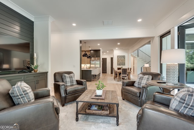 living area with light wood-type flooring, visible vents, crown molding, and recessed lighting