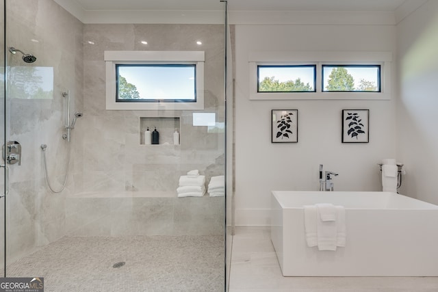 bathroom with a freestanding tub, tiled shower, and plenty of natural light