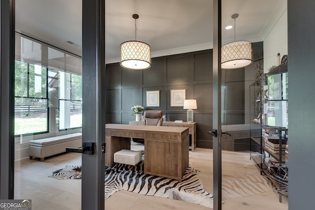 office area featuring visible vents, crown molding, french doors, light wood-style floors, and a decorative wall