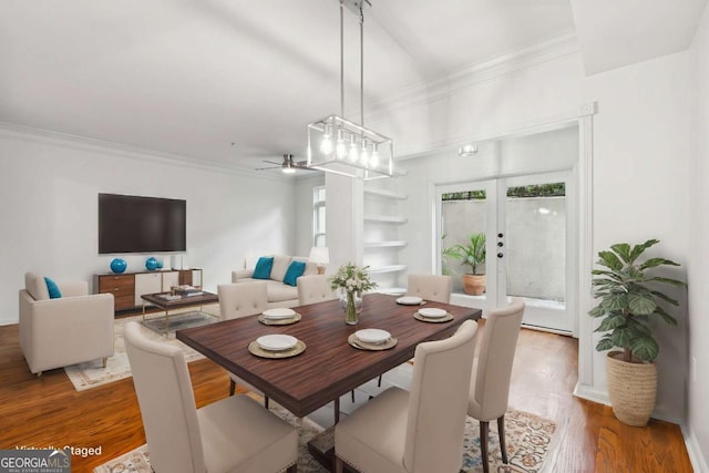 dining space with ornamental molding, ceiling fan, french doors, and wood finished floors