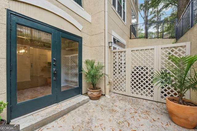 property entrance with french doors, a patio, and stucco siding