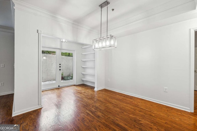 unfurnished dining area featuring built in features, baseboards, ornamental molding, and wood finished floors