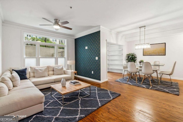 living room with ornamental molding, wood finished floors, baseboards, and wallpapered walls