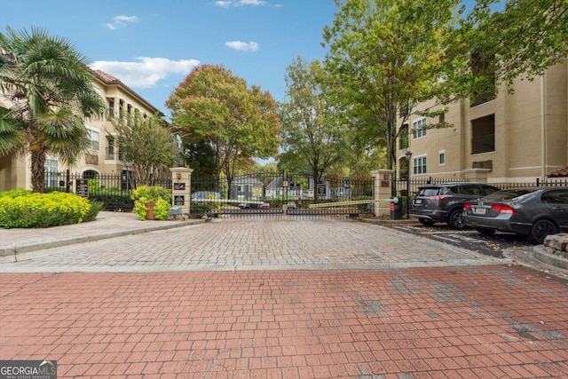 view of road featuring a gate, curbs, and a gated entry