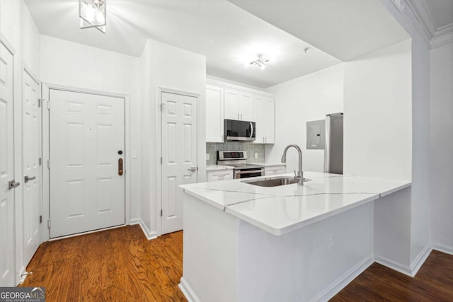 kitchen with stainless steel appliances, a sink, dark wood finished floors, and white cabinets