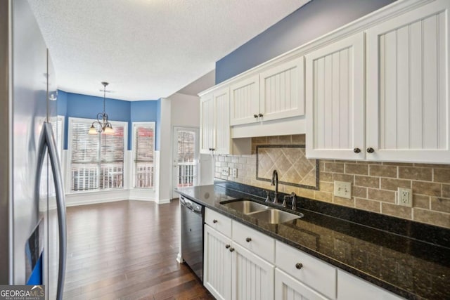 kitchen featuring decorative light fixtures, stainless steel appliances, tasteful backsplash, dark wood-type flooring, and a sink