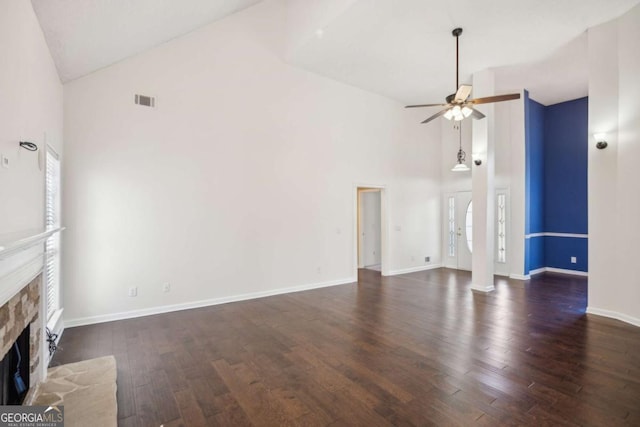 unfurnished living room with a fireplace with raised hearth, high vaulted ceiling, ceiling fan, wood finished floors, and visible vents