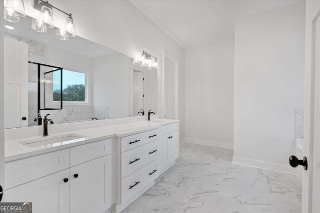 bathroom featuring marble finish floor, a sink, baseboards, and double vanity