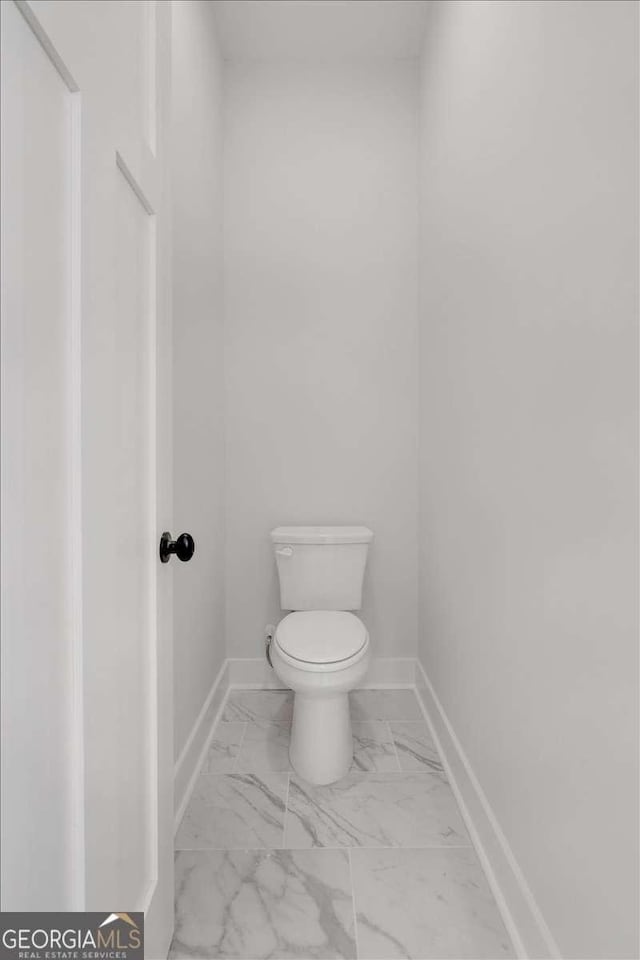 bathroom featuring marble finish floor, toilet, and baseboards