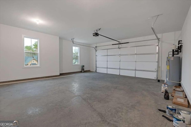 garage featuring water heater, baseboards, and a garage door opener